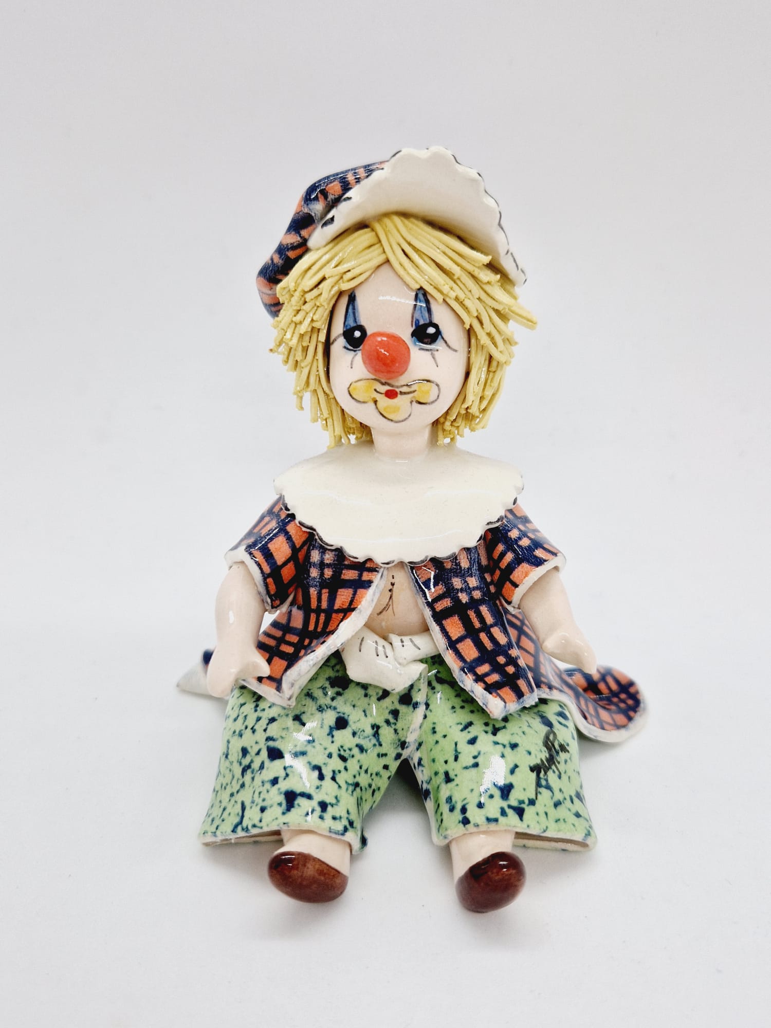 Seated clown yellow spaghetti hair